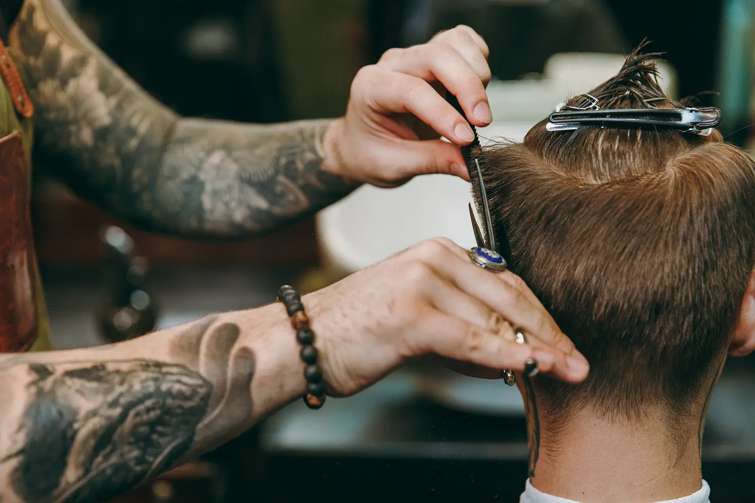 Barbering performing a precision haircut with shears and comb